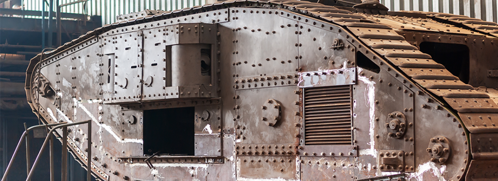 English heavy tank Mark V, of the times of the first world war, in the factory workshop for restoration work. The paint coating is completely removed, polished welding spots are visible.